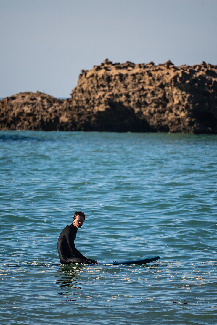 Surfers in Grande Plage beach of Biarritz, France