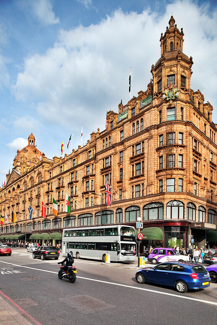 London, UK, May 3 2009, The iconic Harrods building showcases its stunning architecture as double-decker buses and cars pass by on a busy London street.