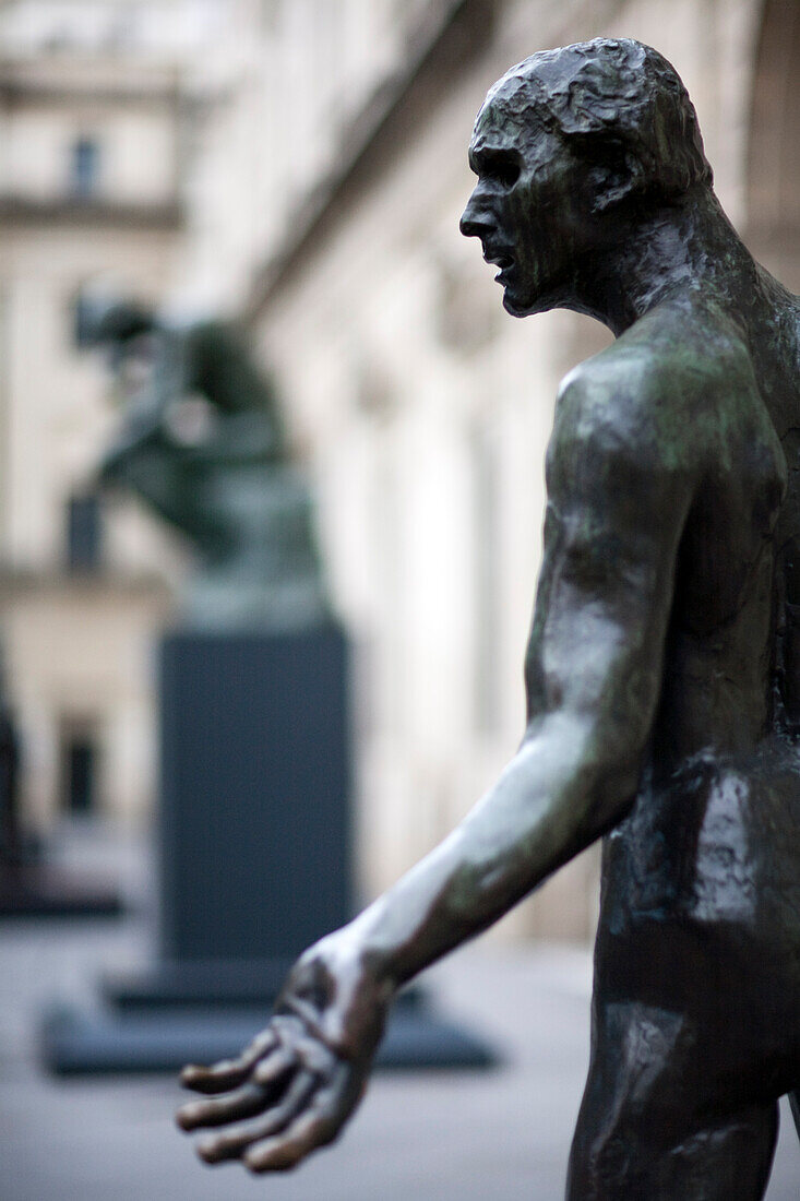 Die Jean de Fiennes-Skulptur von Rodin steht auf der Plaza Nueva, Sevilla, mit dem Denker im Hintergrund im Dezember 2008