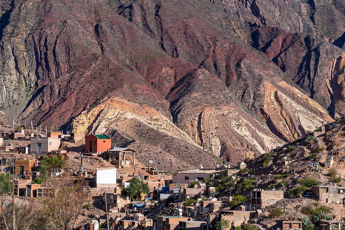 Tombs in the Our Lady of Carmen Cemetery in Maimara in the Humahuaca Valley or Quebrada de Humahuaca, Argentina. Behind is the Painter's Palette, a colorful geologic anticline.