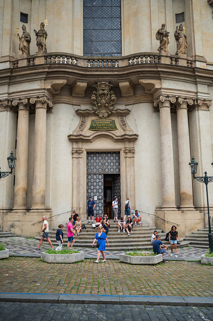 People in the entrance stairs of Church of St. Nicholas, Prague