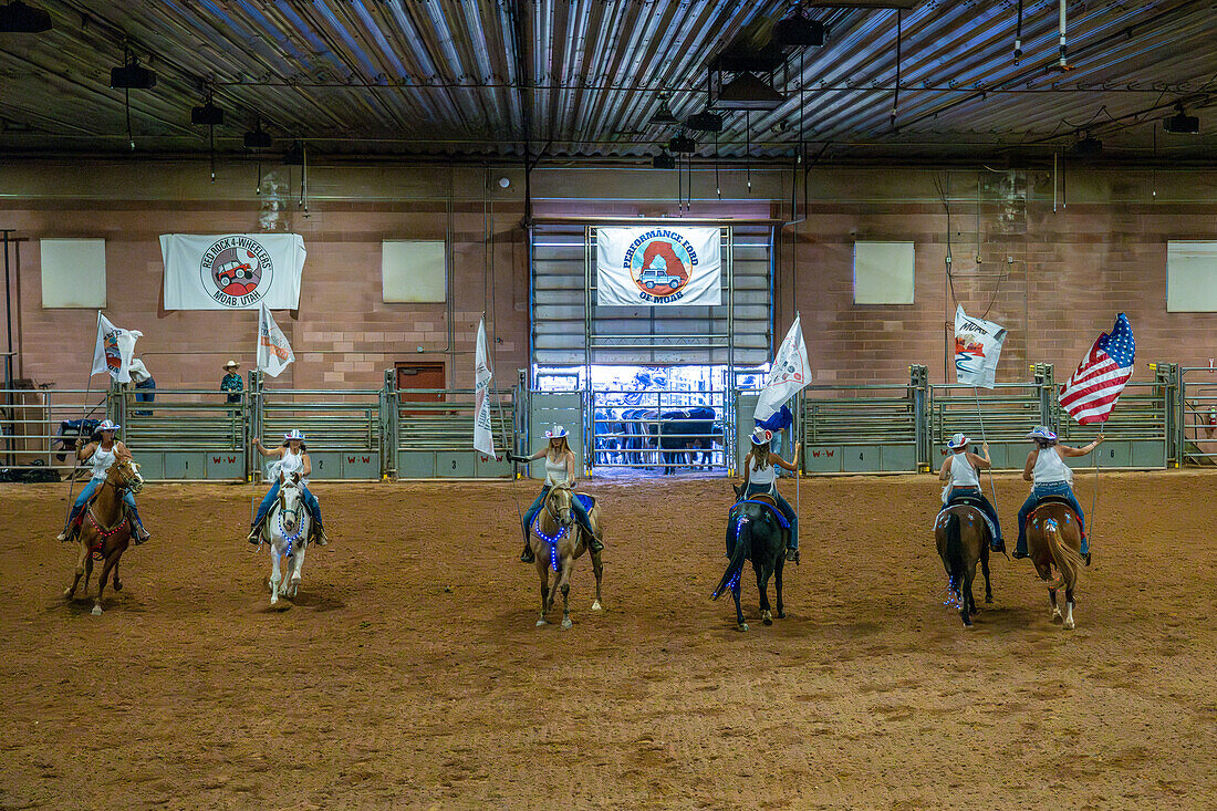 Cowgirls in einem berittenen Drillteam treten zu Beginn des Moab Junior Rodeo in Moab, Utah, mit Fahnen auf