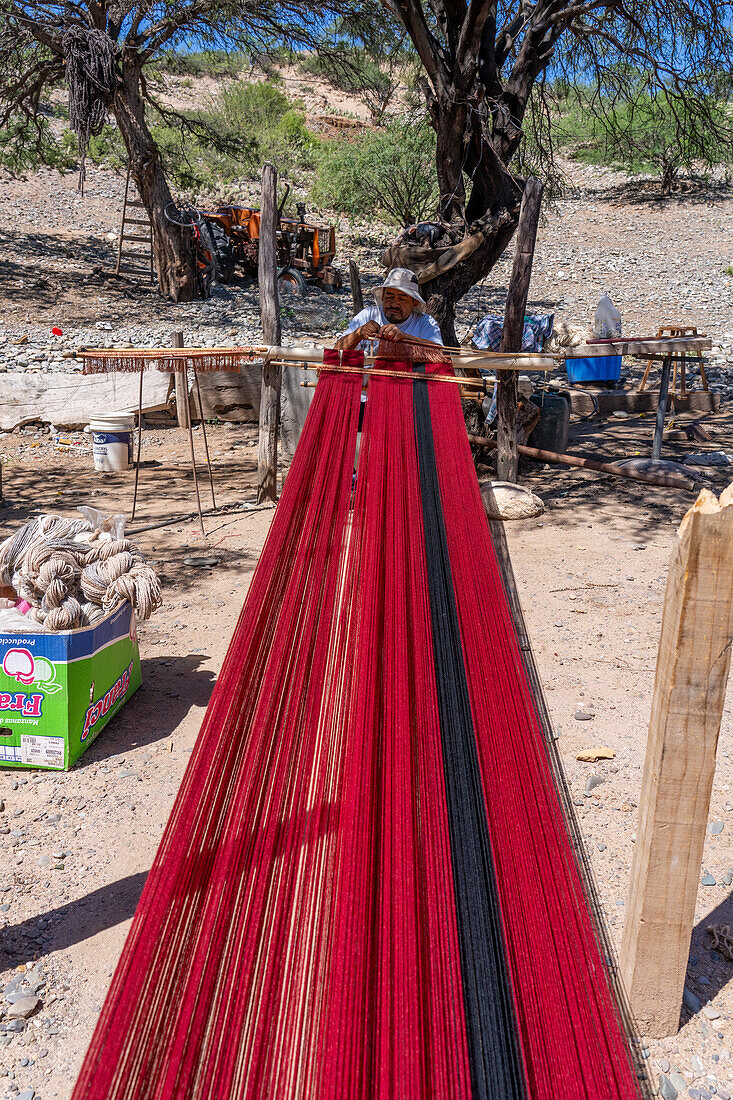 A man weaving on a wooden foot loom in Seclantas, Argentina in the Calchaqui Valley.