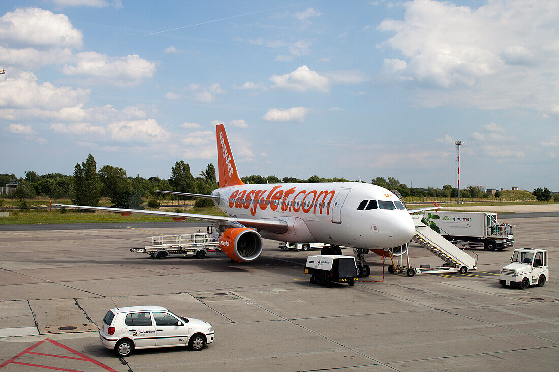 Berlin, Germany, July 21 2009, An EasyJet aircraft is parked on the tarmac at Schönefeld airport in Berlin, with ground crew preparing for passenger boarding.