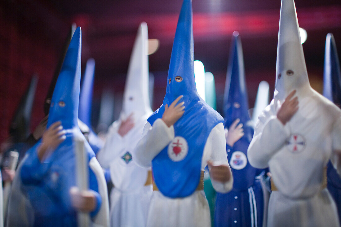 Colorful figures of nazarenos are showcased for sale in a Semana Santa shop in Sevilla, capturing the essence of the tradition.