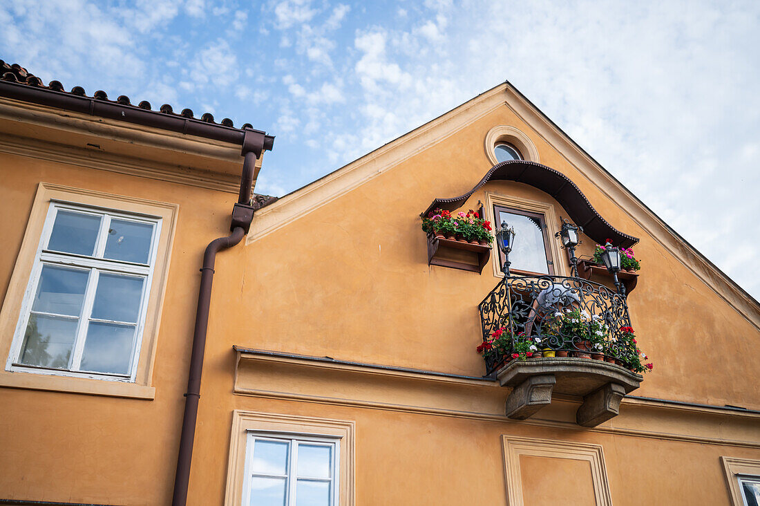 Beliebter Renaissance-Balkon mit Blumen und einem Bild der Jungfrau Maria, Prag