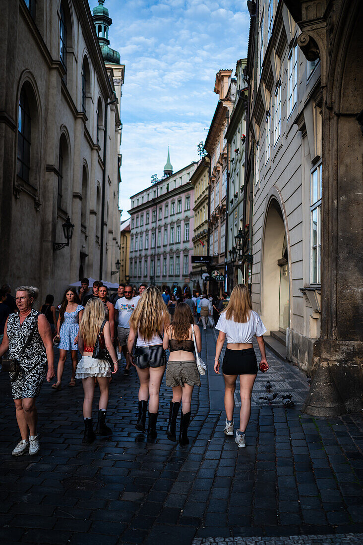 Young girls walking in Prague, view from behind