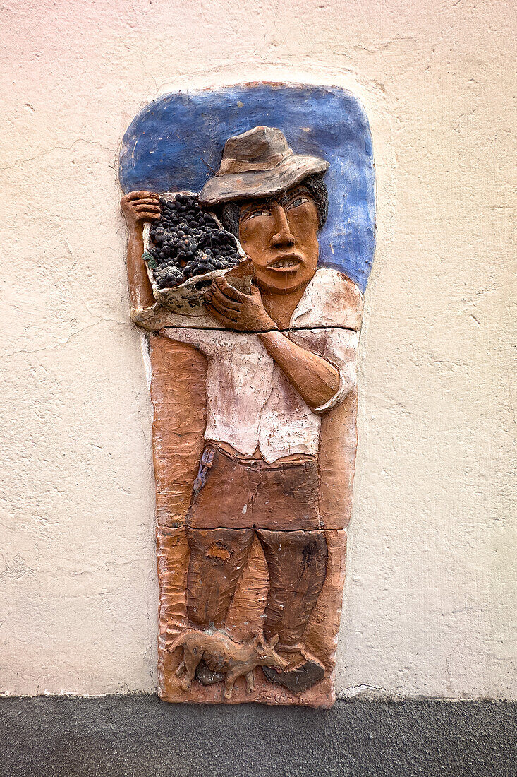 Basrelief-Skulptur eines Mannes, der Weintrauben erntet. Museo de la Vid y el Vino oder Museum der Rebe und des Weins. Cafayate, Argentinien