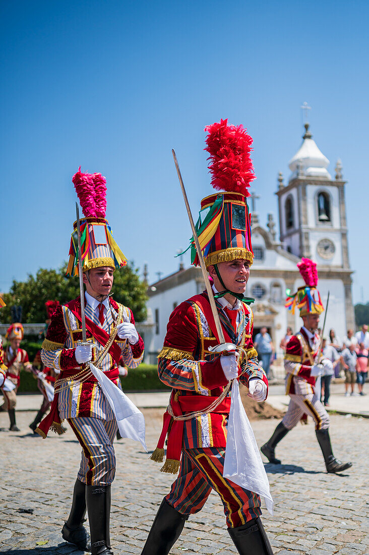 Parade passing by São João Baptista Church during The Festival of Saint John of Sobrado, also known as Bugiada and Mouriscada de Sobrado, takes place in the form of a fight between Moors and Christians , locally known as Mourisqueiros and Bugios, Sao Joao de Sobrado, Portugal