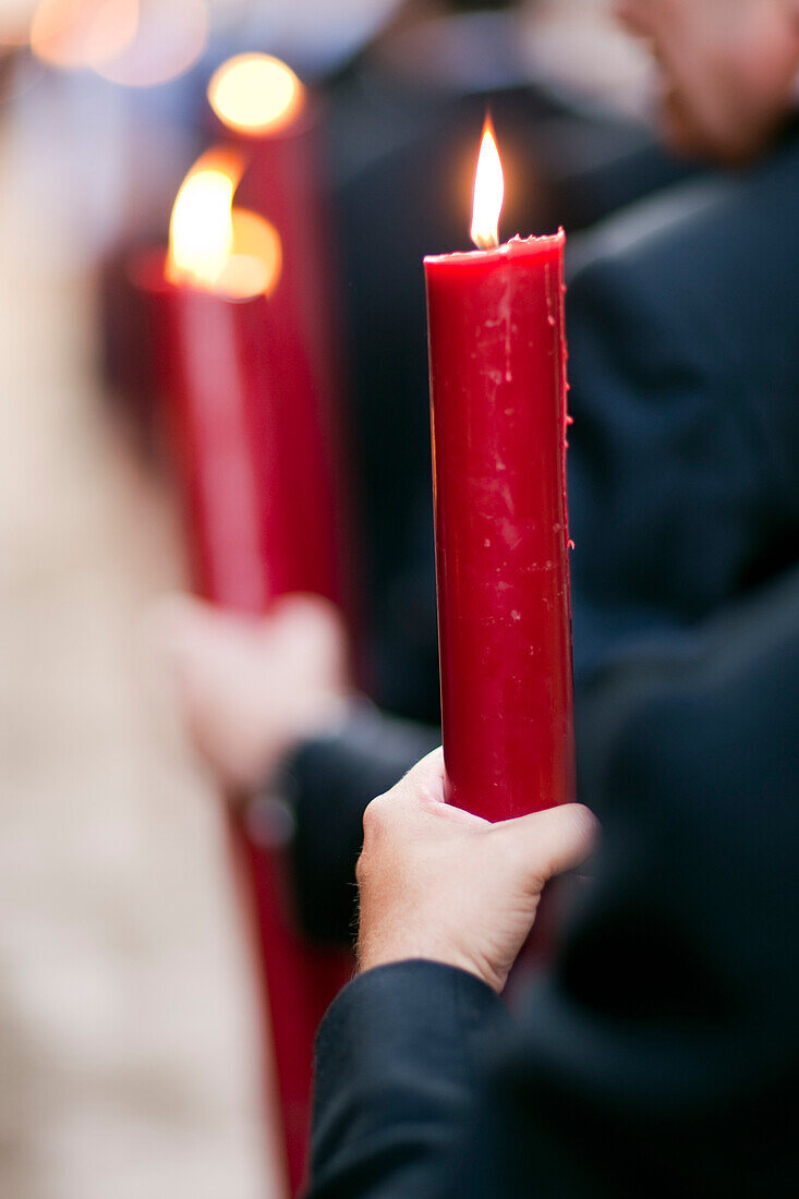 Brotherhood members of Seville hold lit candles while participating in the Corpus Christi procession in 2009.