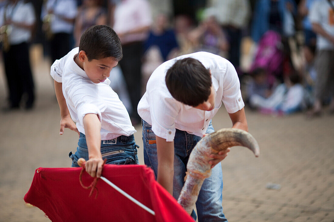 Seville, Spain, June 11 2009, Young bullfighter trainees engage in toreo de salon at Alameda de Hercules square, showcasing their skills and techniques.