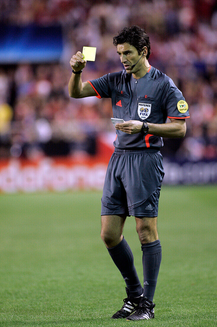 Seville, Spain, March 4 2008, Referee Massimo Bussacca cautions a player with a yellow card during the tense Champions League match in Sevilla.