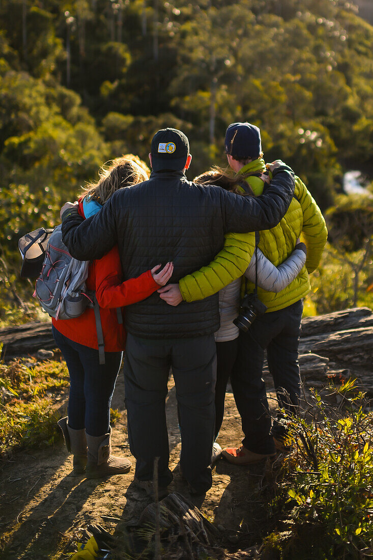 Group of people posing for a photo in the mountains, view from behind