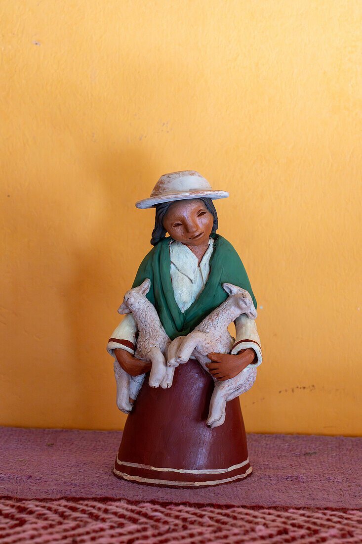 A ceramic Aymara woman with lambs by indigenous Aymara ceramic artist Santina Alabar in Purmamarca, Argentina.