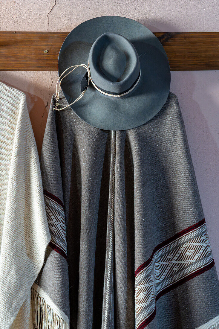 Hand-woven pancho & gaucho hat for sale at a home weaving shop in Seclantas, Argentina in the Calchaqui Valley.