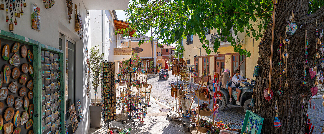 View of souvenir shop and couple on quad bike in Theologos, Theologos, Thassos, Aegean Sea, Greek Islands, Greece, Europe