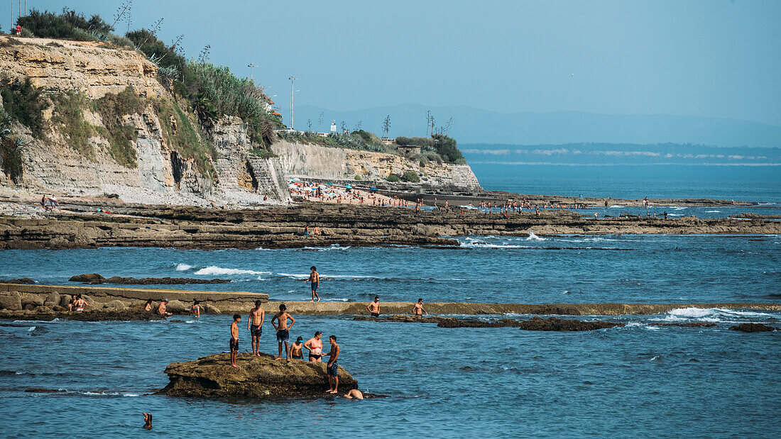 Menschen entspannen sich am Strand Avencas in Sao Pedro do Estoril bei Lissabon, Portugal, Europa