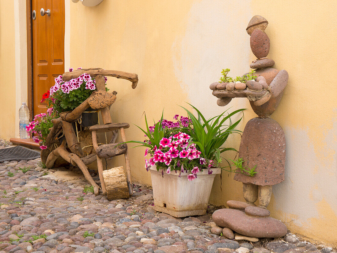 Kunstvolle Dekoration aus Holz, Steinen und Blumen auf der gepflasterten Via Ospedale im Herzen der Altstadt, Alghero, Sassari, Sardinien, Italien, Mittelmeer, Europa