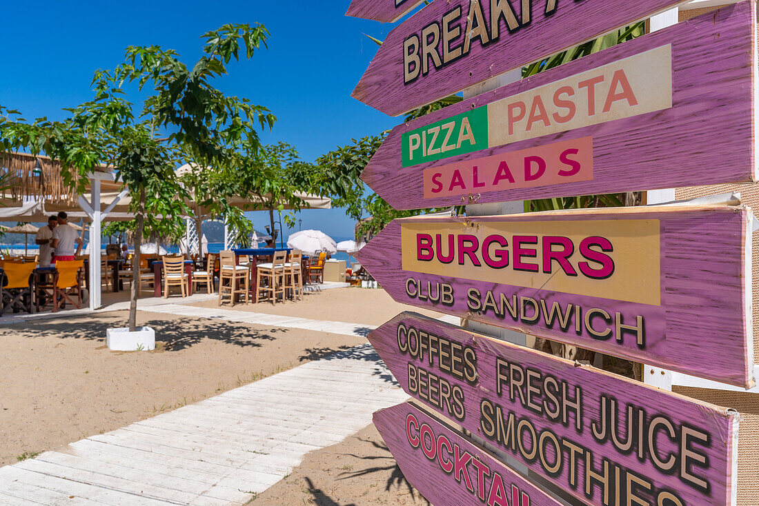 View of restaurant signs and harbour in Thassos Town, Thassos, Aegean Sea, Greek Islands, Greece, Europe