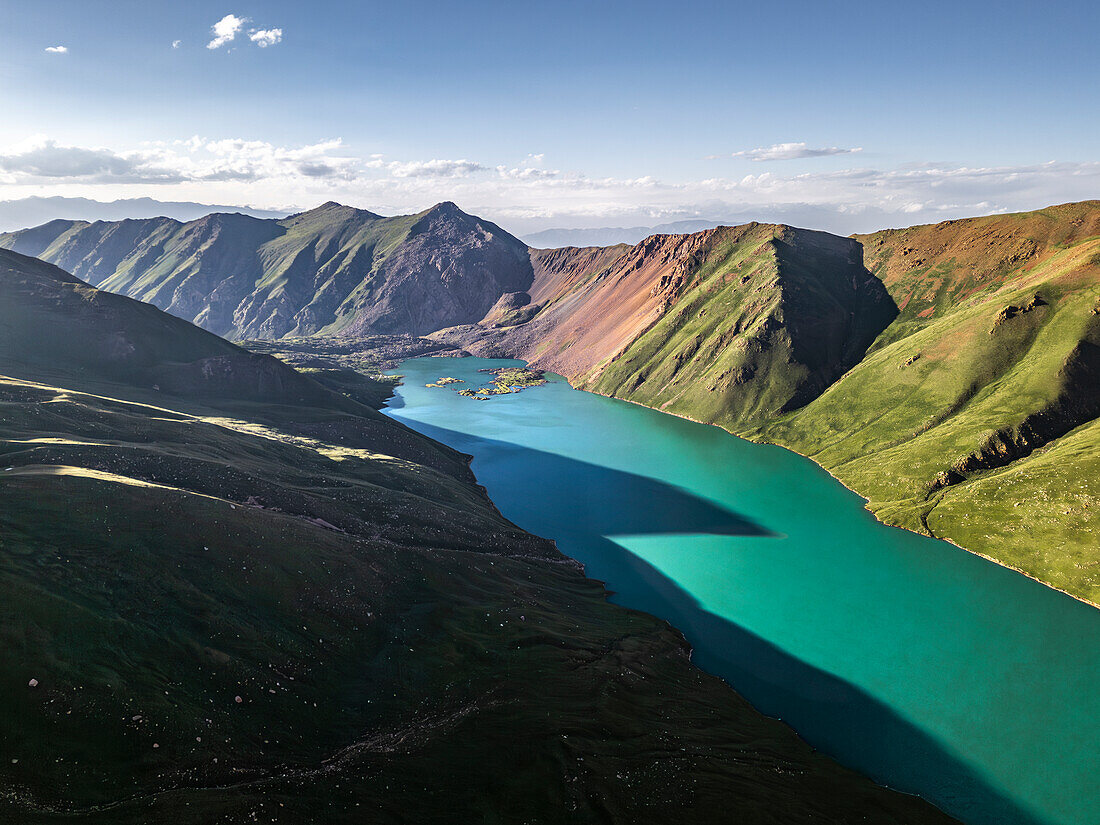 Luftaufnahme des Kol-Ukok-Sees, umgeben von grünen Bergen unter blauem Himmel, Kirgisistan, Zentralasien, Asien