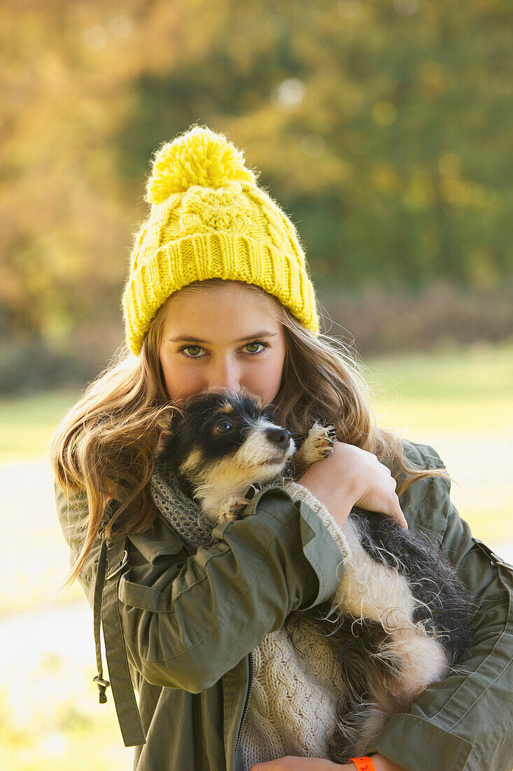 Teenage Girl Hugging Puppy Outdoors