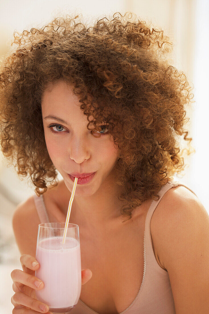 Young Woman Drinking Smoothie with Straw