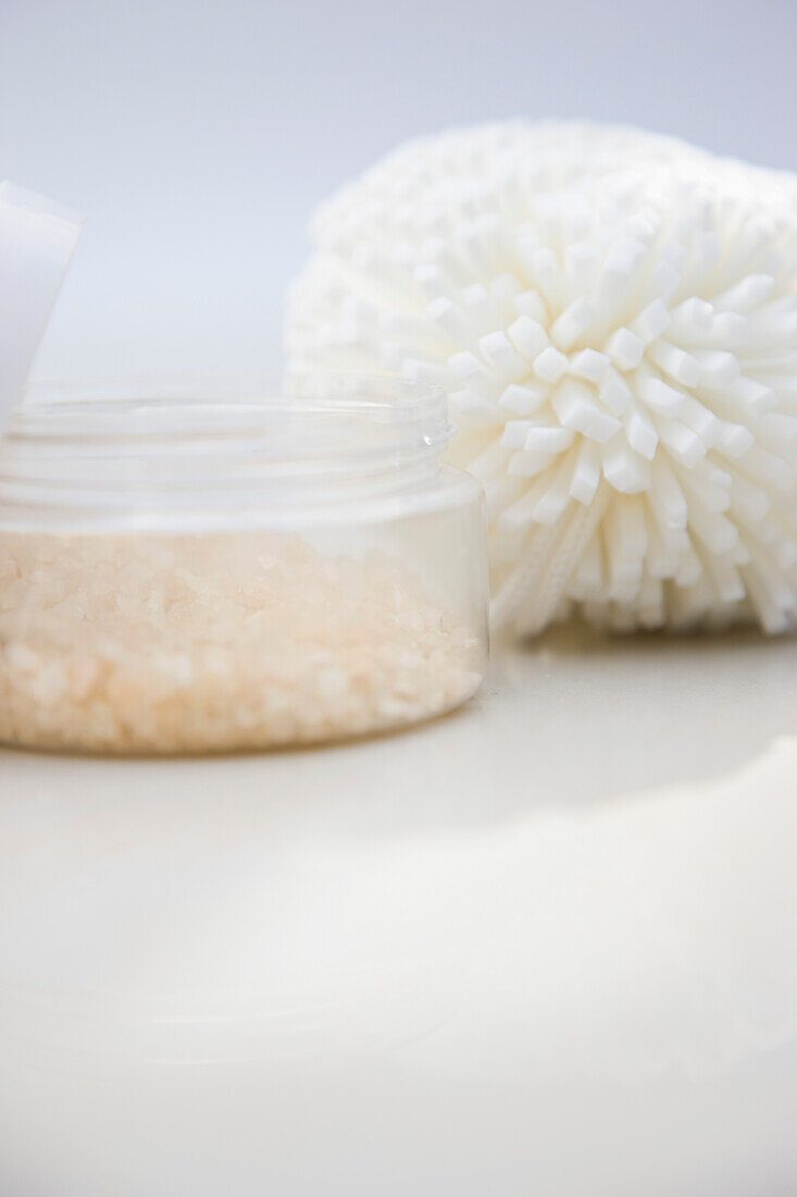 Close up of a jar of bath salts and sponge