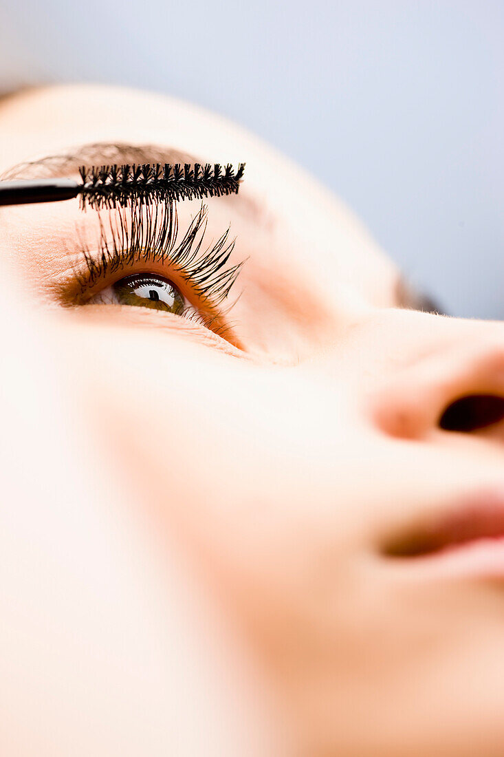 Extreme close up of a woman applying mascara