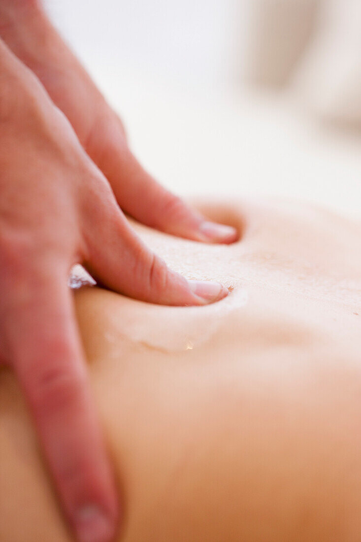 Extreme close up of a masseur hands on a woman back