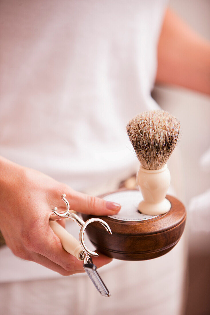 Frau hält Rasierapparat in der Hand