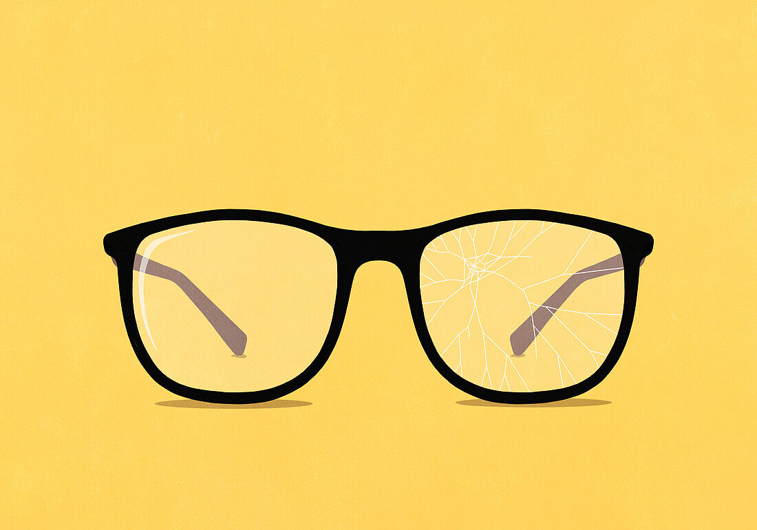 Large eyeglasses with cracked lens on yellow background