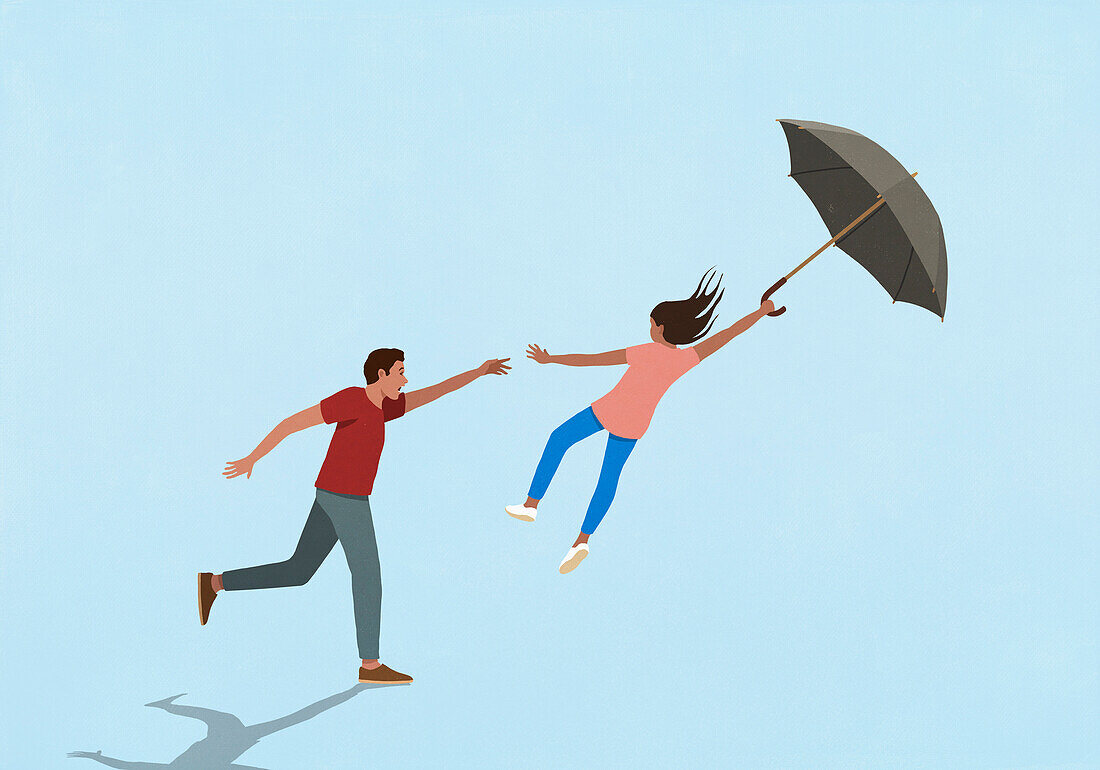 Father reaching for daughter blowing away with umbrella in wind on blue background