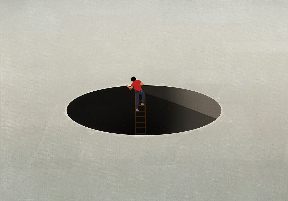 Man climbing ladder out of large hole