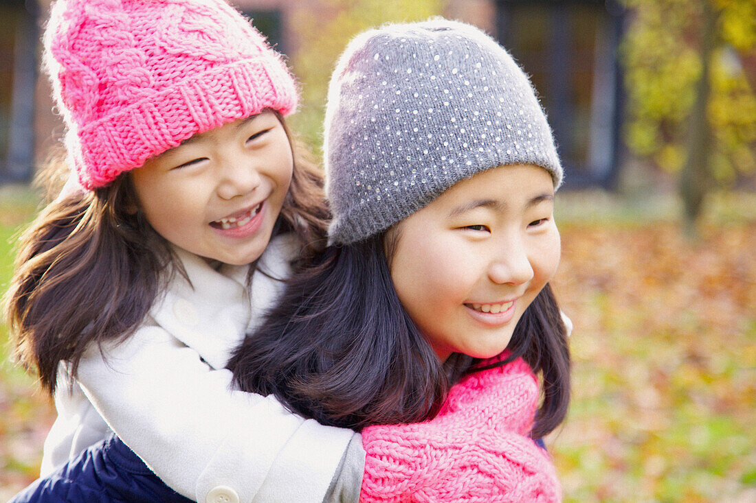 Two Young Girls Riding Piggyback Outdoors