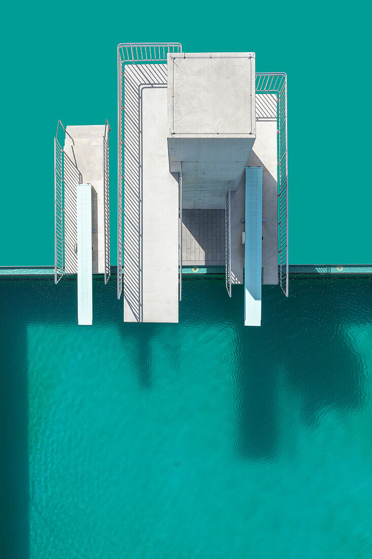 View from above diving platforms and diving boards above turquoise blue swimming pool