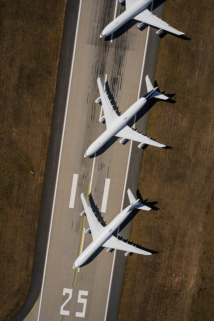 View from above passenger airplanes parked on sunny airport runway