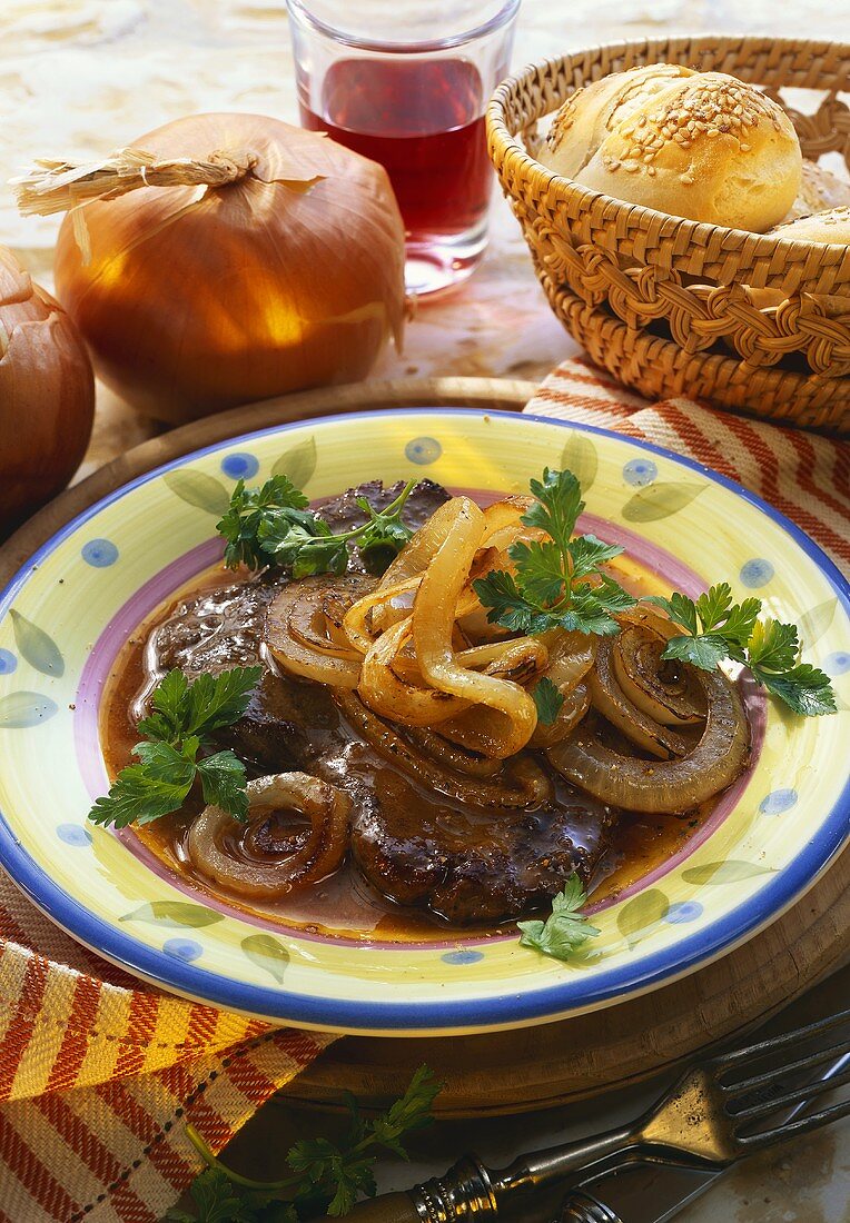 A slice of steak with onions on plate