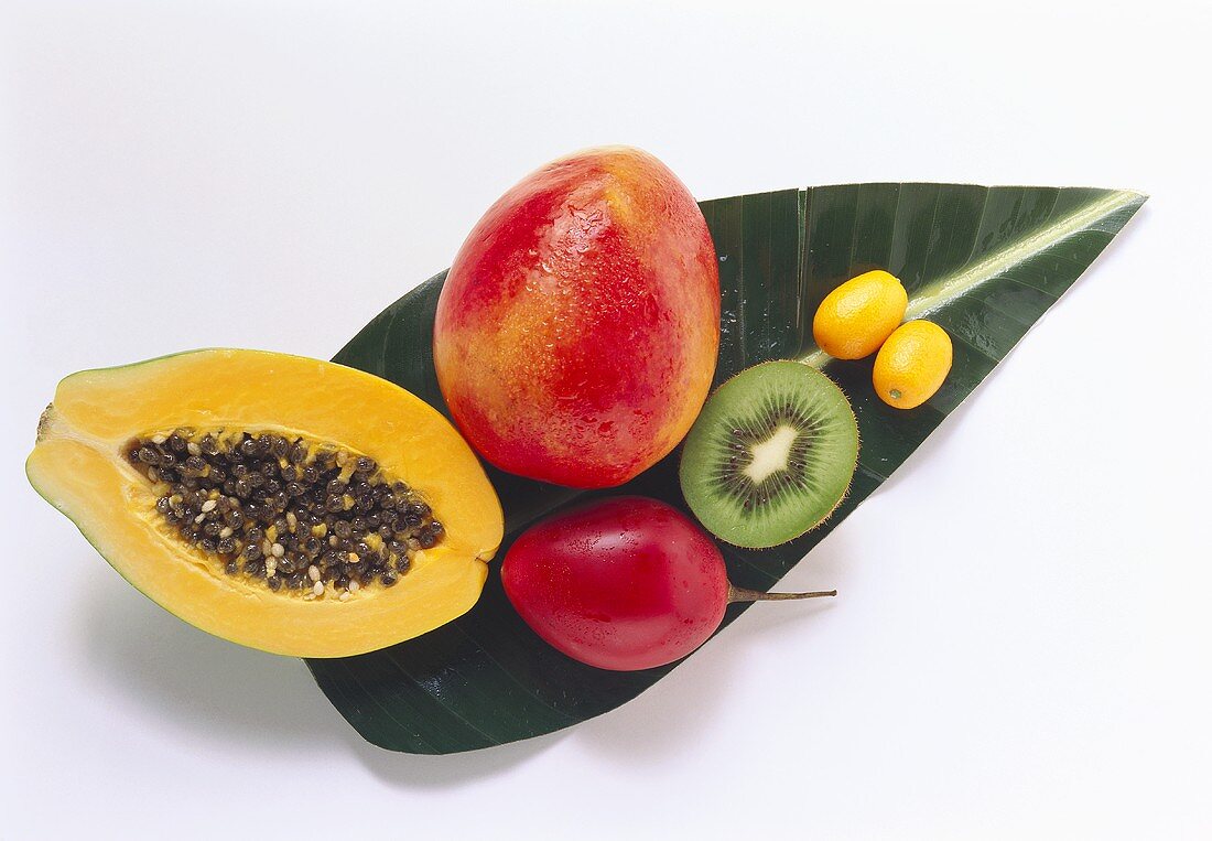 Exotische Früchte mit Wassertropfen auf Bananenblatt
