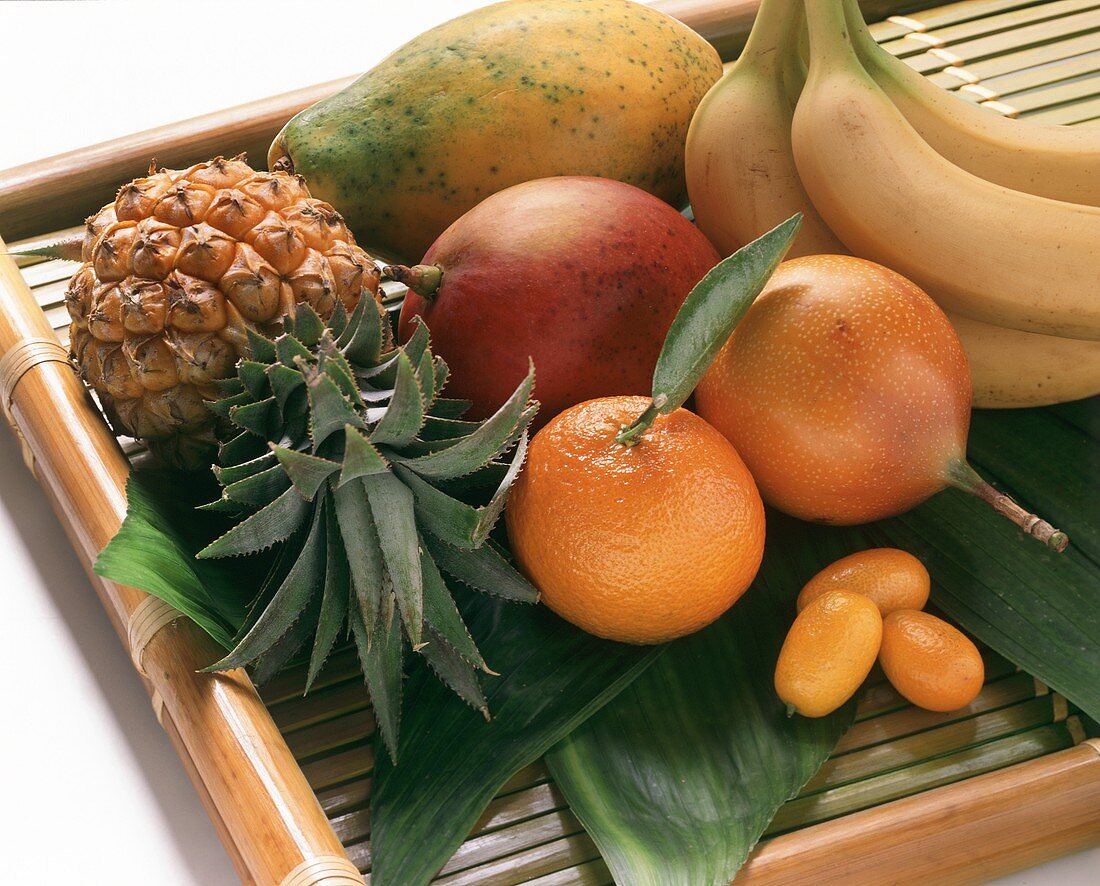 Exotic fruits with mandarin and kumquats on tray