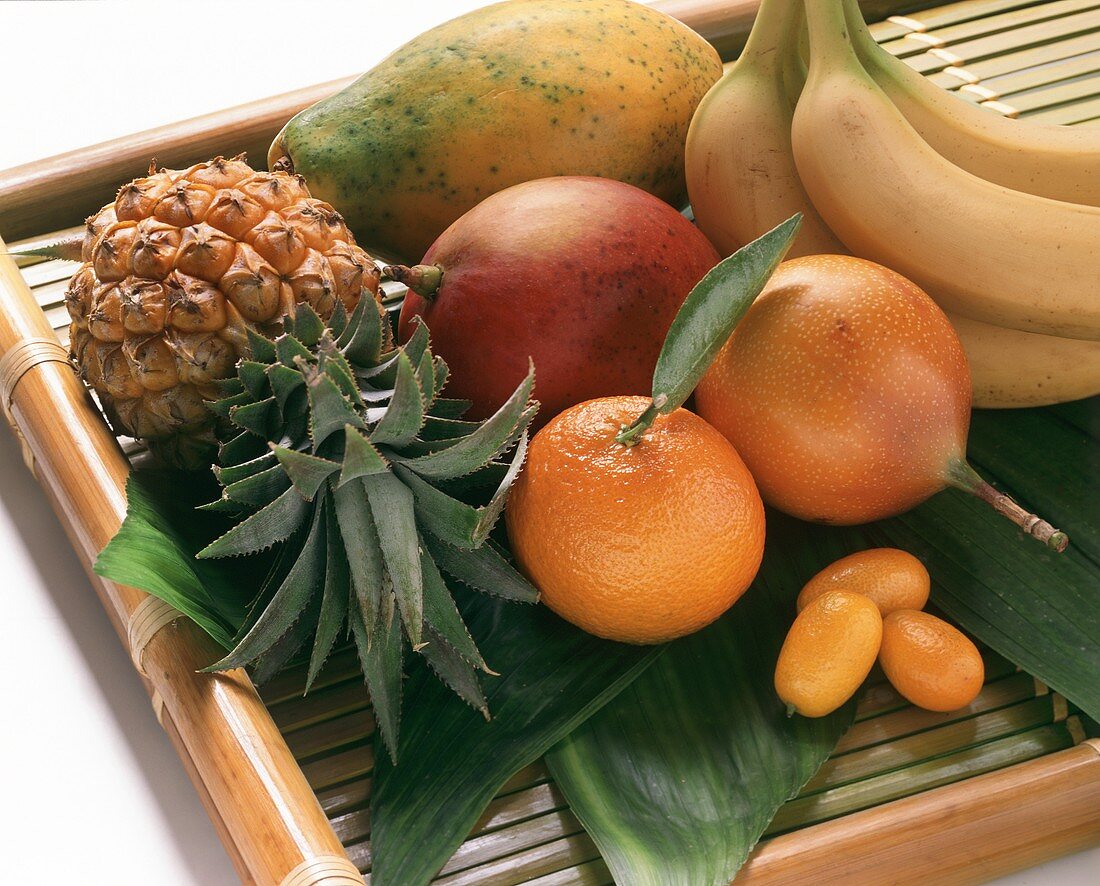 Exotische Früchte mit Mandarine und Kumquats auf Tablett