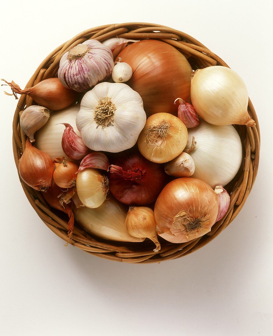 Verschiedene Zwiebelsorten und Knoblauch in einem Korb