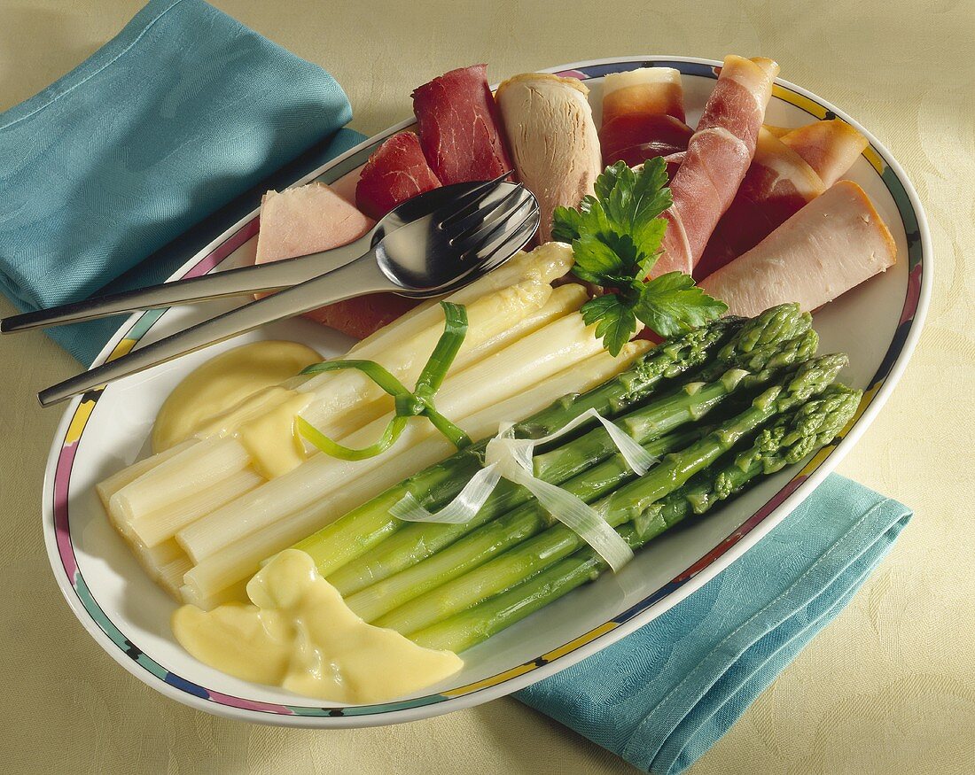 Asparagus with hollandaise sauce and sliced sausage 