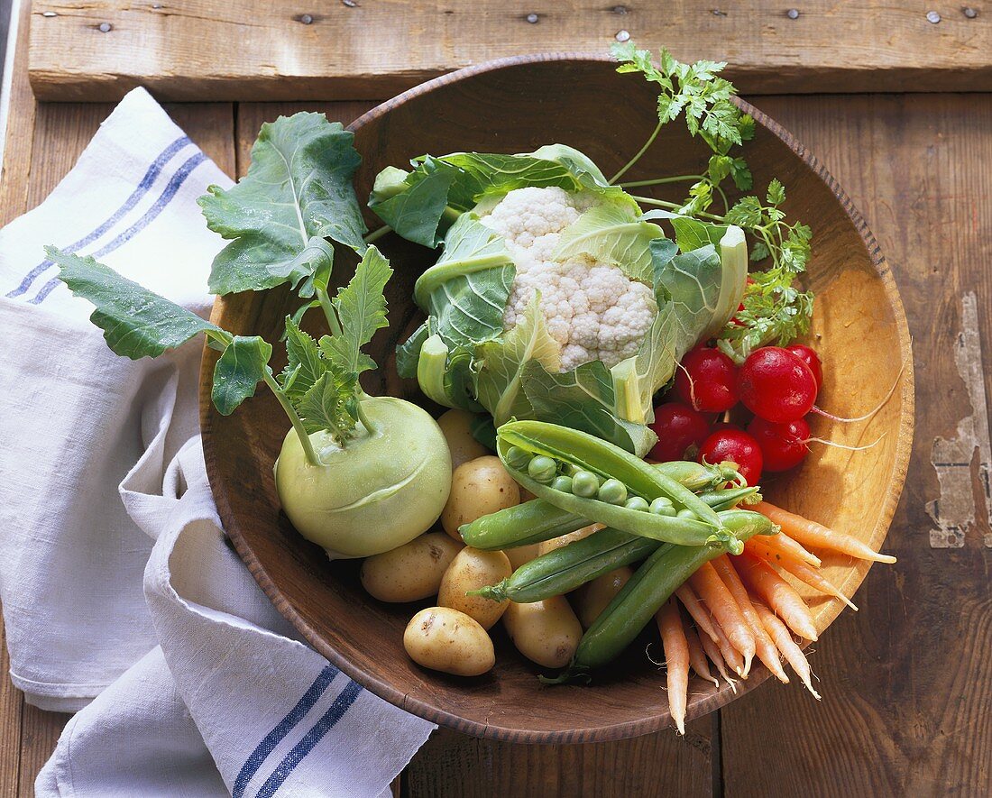 Various spring vegetables in wooden bowl