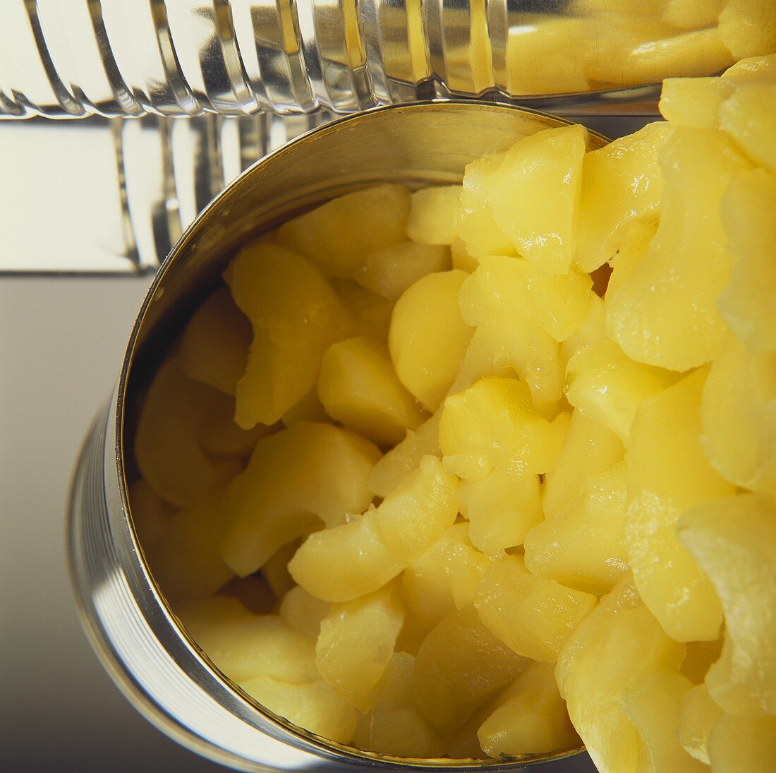 Apple pieces (compote) falling out of opened tin