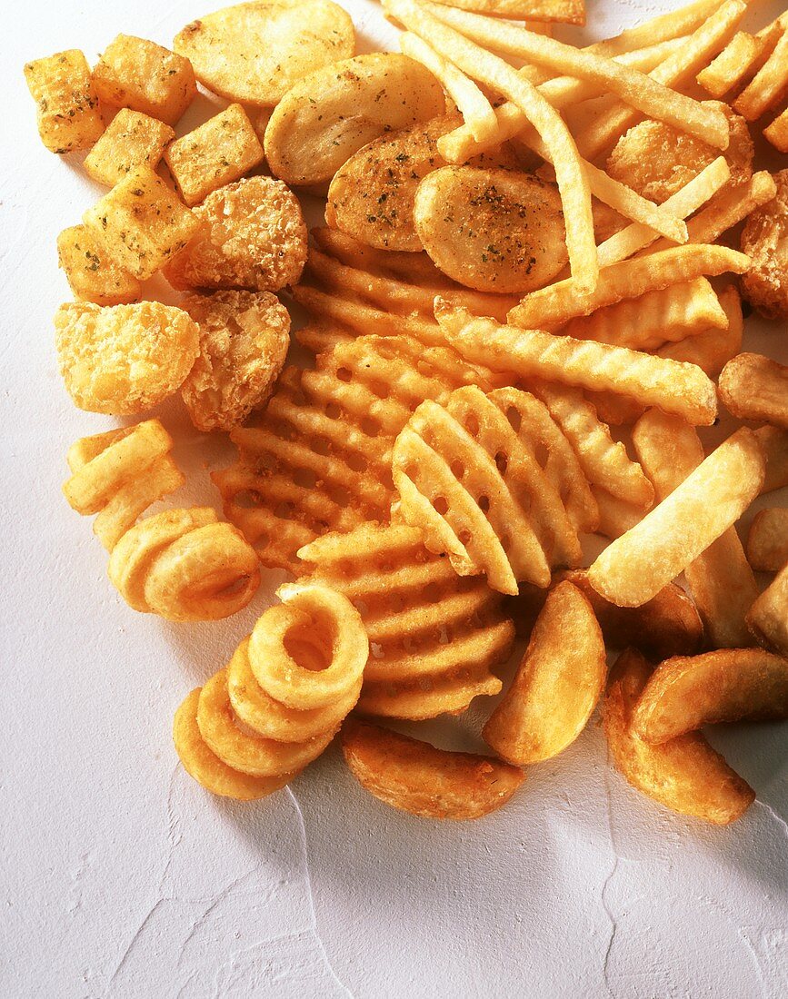 Verschiedene fritierte Kartoffelprodukte: Chips, Pommes etc.