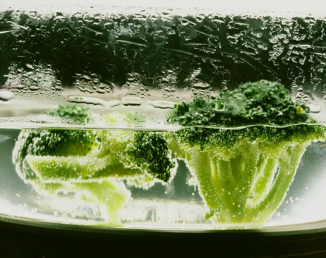 Broccoliröschen im kochenden Wasser in einem Glastopf