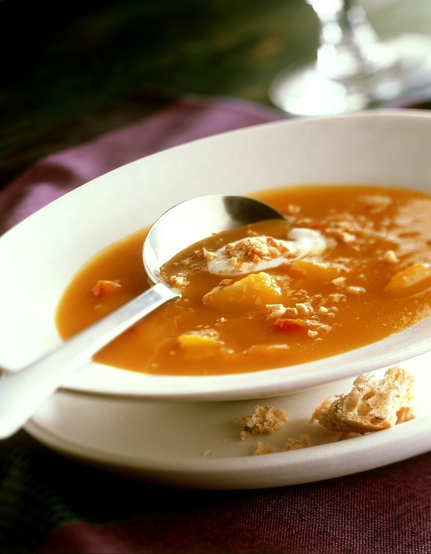 Pumpkin soup on plate with spoon