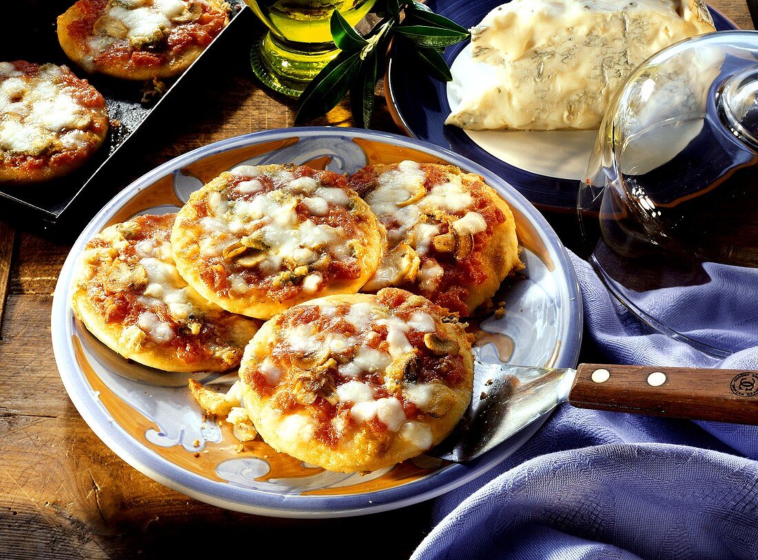 Mini-pizzas with tomatoes, mushrooms and cheese