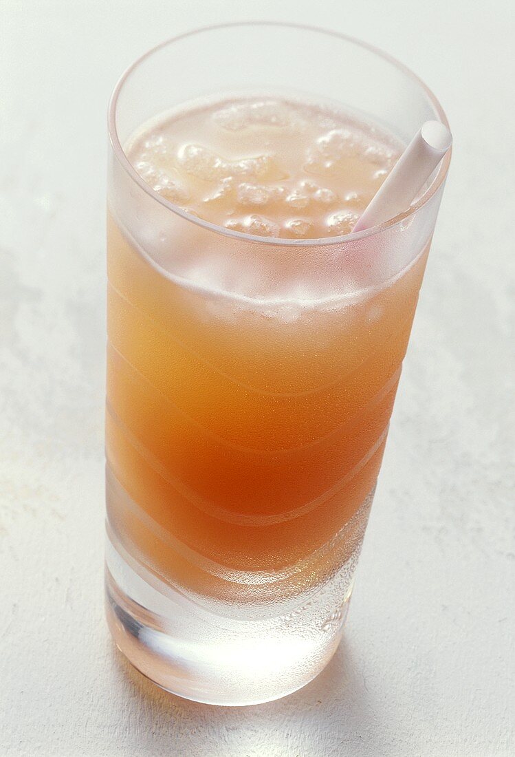 Grapefruit drink with crushed ice and straw in glass