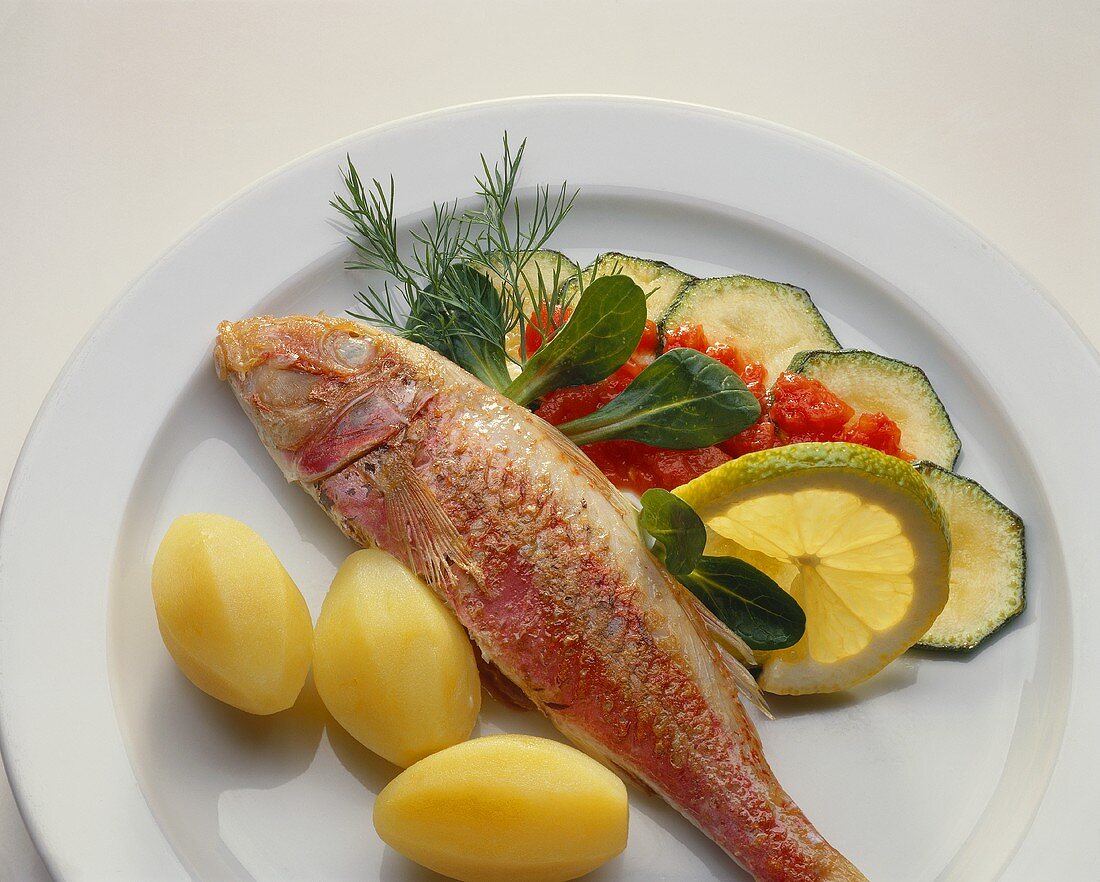 Fried red mullet with courgettes & potatoes on plate